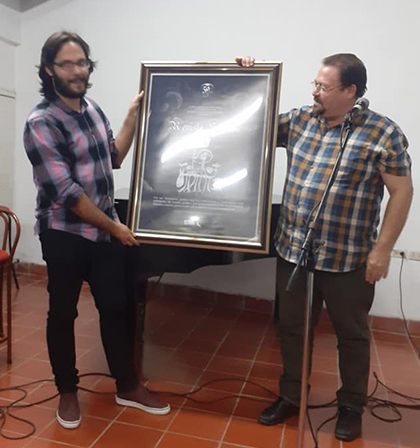 Serguey Pérez, director de Cultura en Villa Clara, entrega reconcimiento a José Ernesto Nováez Guerrero, nuevo director de Signos.