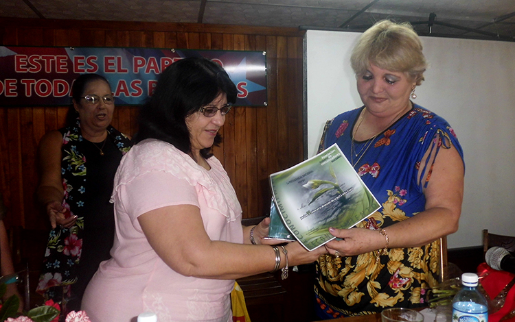 Rosa Marí­a Pérez Gutiérrez, presidenta nacional de la ACCS, reconoce a Zaida dela Cruz, expresidenta de la ACCS de Villa Clara.