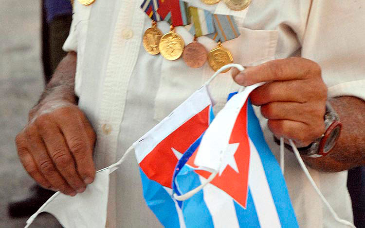 Combatiente con medallas y bandera cubana.