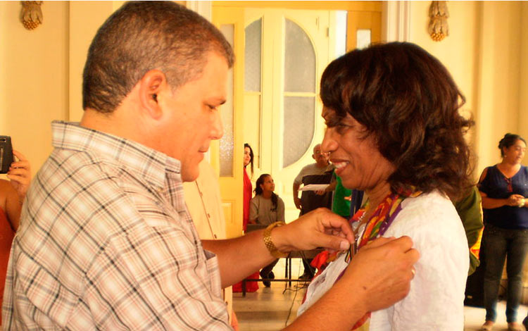 Julio Lima Corzo condecora a Isabel Julia Veitía Arrieta.