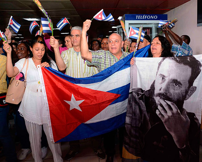 Cooperantes cubanos procedentes de Bolivia portan bandera cubana.