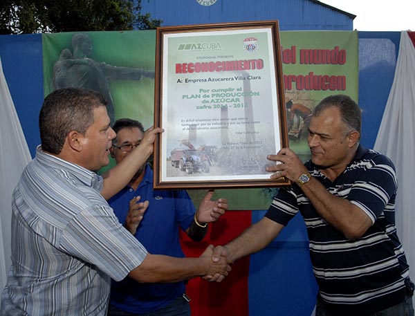 Julio Lima Corzo entrega diploma de cumplimiento de la zafra a Andrés Durán Fundora.