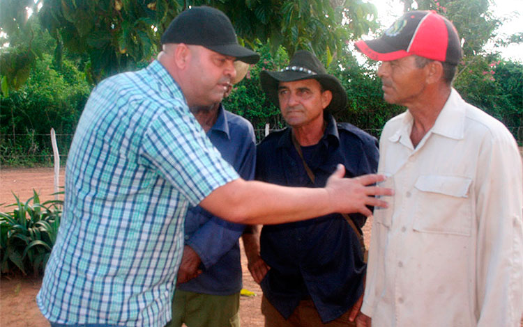 Primer secretario del Partido en Villa Clara, Osnay Miguel Colina, dialoga con Miguel Morales Dí­az, presidente de la Cooperativa de Producción Agropecuaria Mariana Grajales.