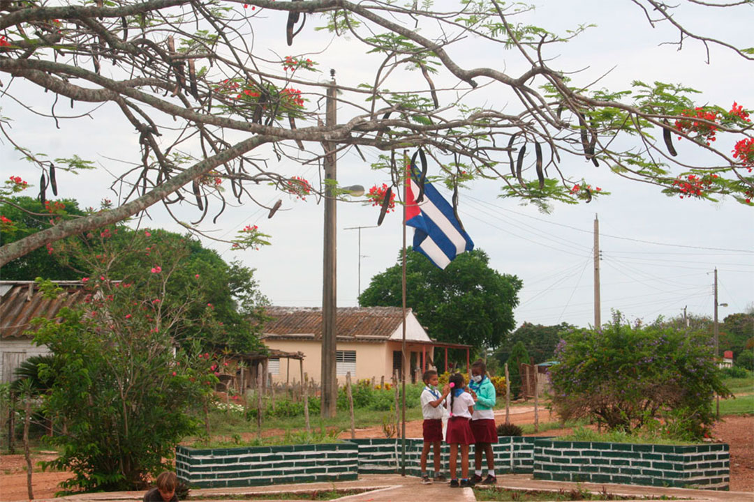 Pioneros izan la bandera en una escuela rural en Villa Clara.