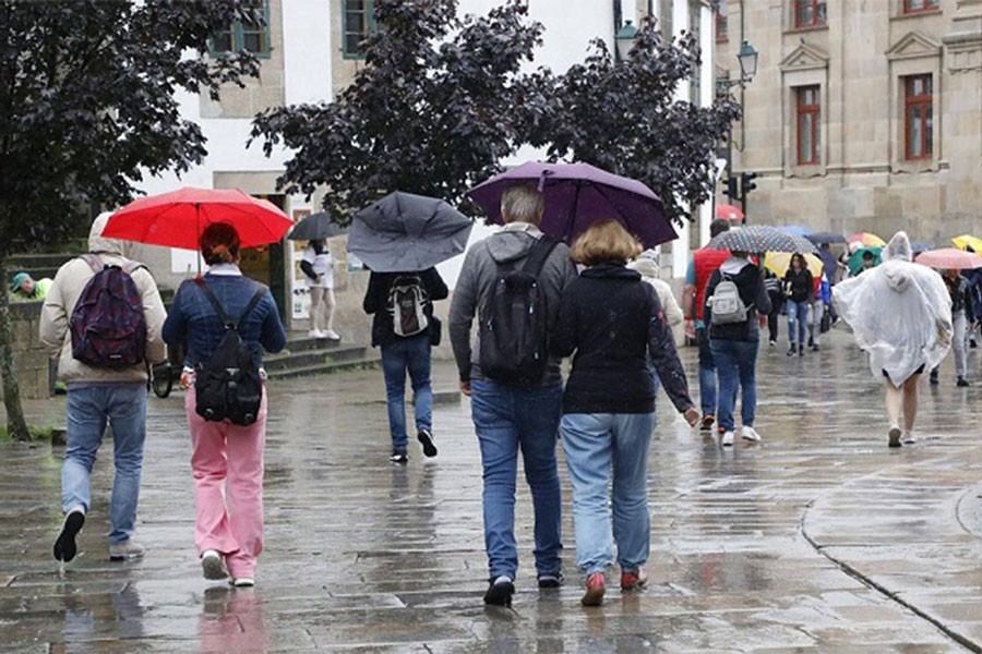 Personas caminando bajo la lluvia.