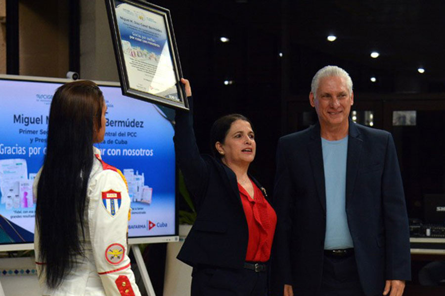 Presidente cubano, Miguel Díaz-Canel, entrega reconocimiento a Marta Ayala, directora del CIGB.