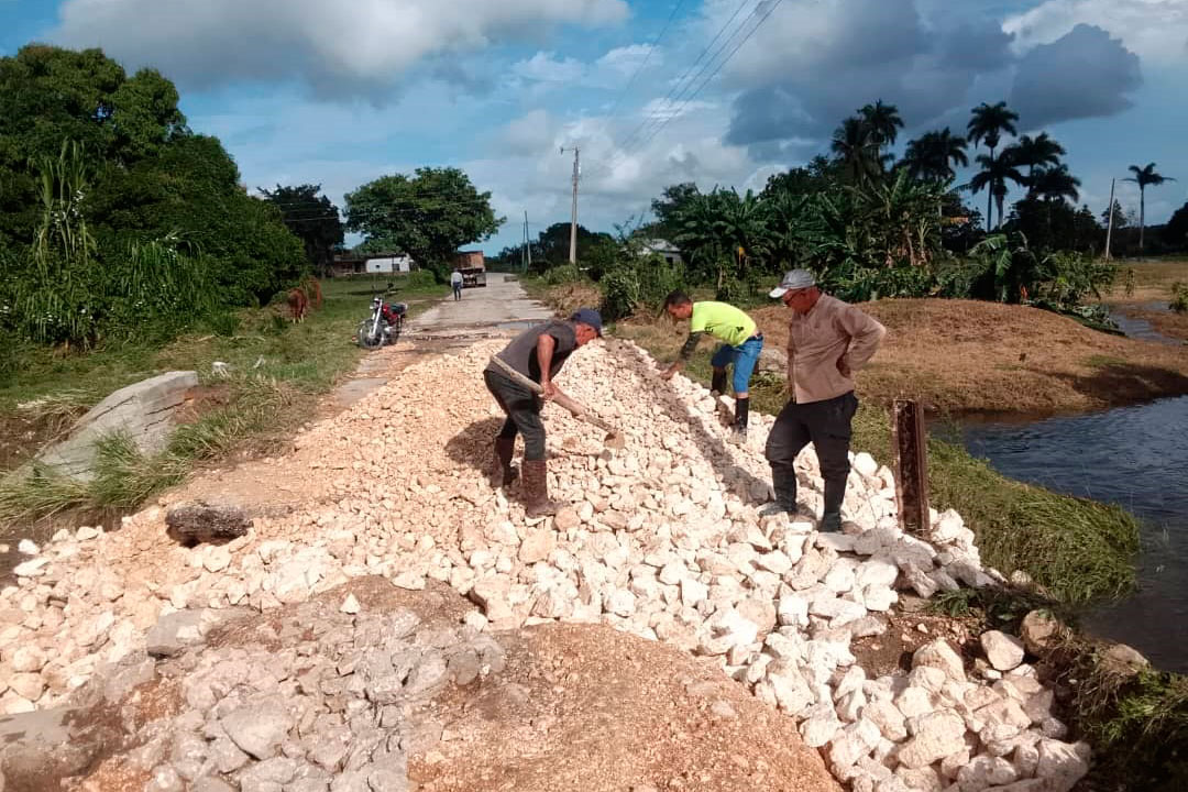 Trabajadores participan en la reparación del puente que comunica a la comunidades de Mariana Grajales y Larrondo, en Sagua la Grande.