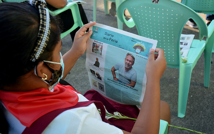 Niña leyendo el Diario de la Feria del Libro de Villa Clara.