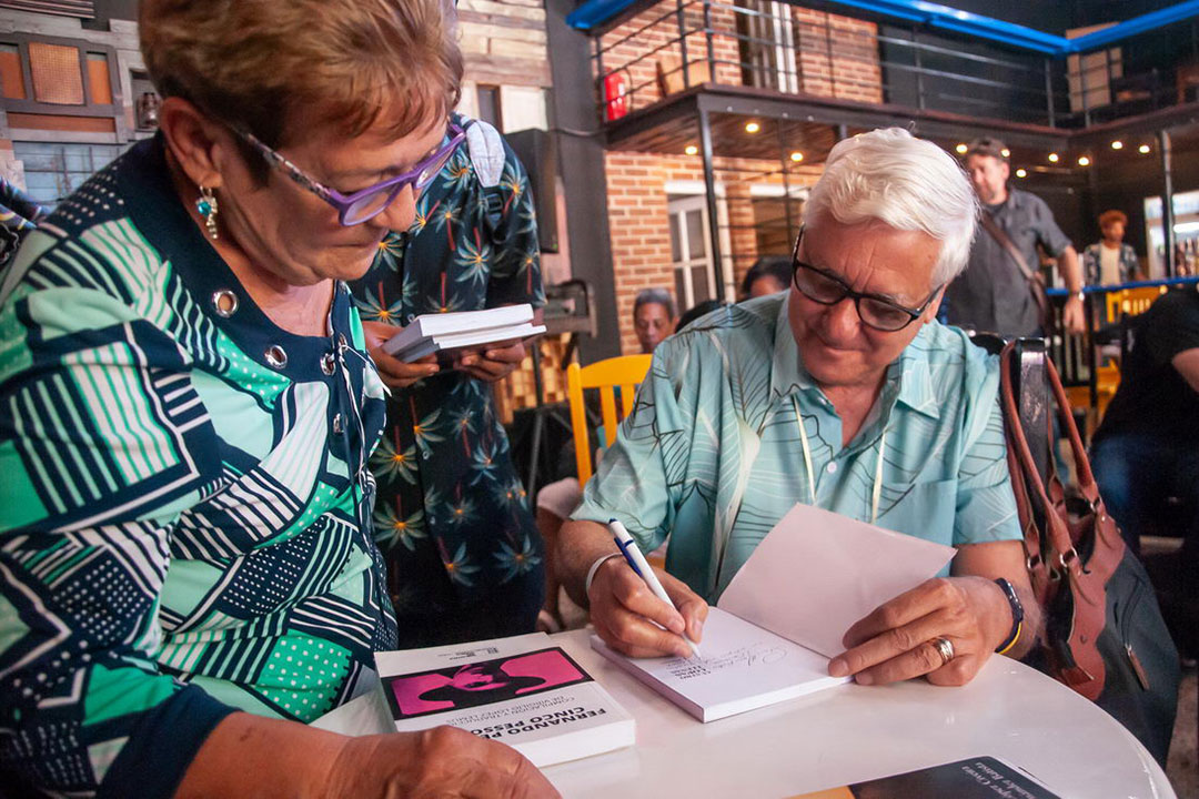 Virgilio López Lemus autografía su libro.