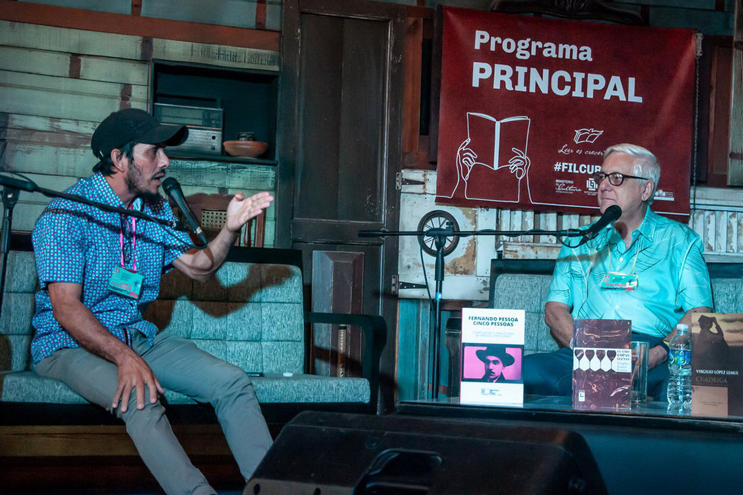 El escritor villaclareña Idiel García dialoga con Virgilio López Lemus durante el homenaje y presentación de sus libros efectuado en el Centro La luna naranja.