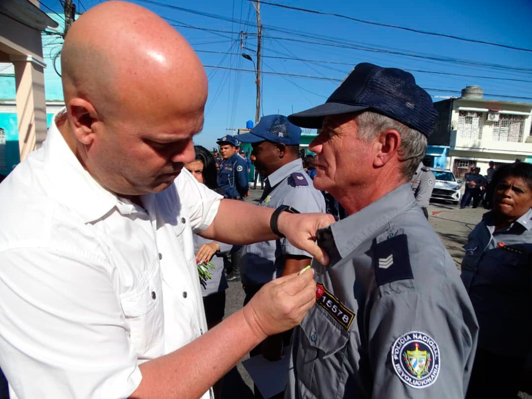 Osnay Miguel Colina, primer secretario del PCC en Villa Clara, condecora a combatiente de la Policía Nacional Revolucionaria.