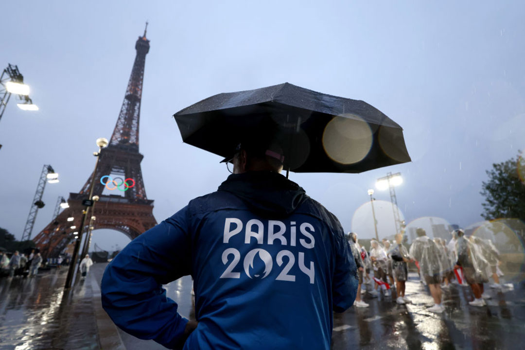 Personal de apoyo se protege de la lluvia en París.