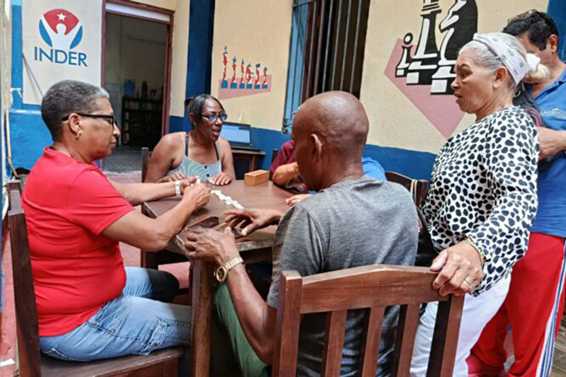 Las glorias deportivas compartiendo en un juego de dominó.