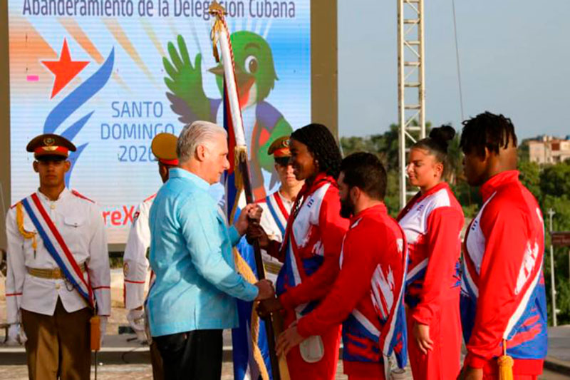 Presidente cubano, Miguel Díaz-Canel, entrega bandera a tripllista Leyanis Pérez.