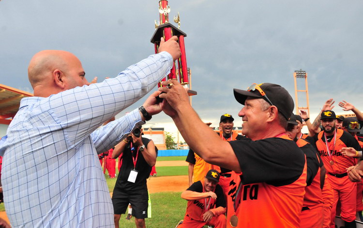 Osnay Miguel Colina, primer secretario del Partido en Villa Clara, entrega el trofeo de la VII Serie Nacional de Béisbol Sub-23 al mánager del equipo Villa Clara, Julio César ílvarez.