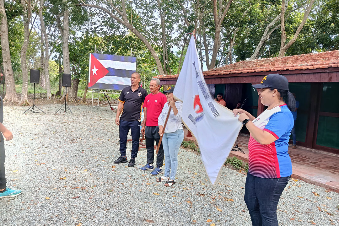 Primera secretaria del PCC en Villa Clara y la gobernadora de la provincia portan la bandera del equipo Villa Clara de béisbol.