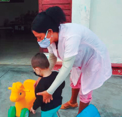 Un niño juega acompañado por su educadora en el cí­rculo infantil Pequeños Lenin, de Santa Clara.