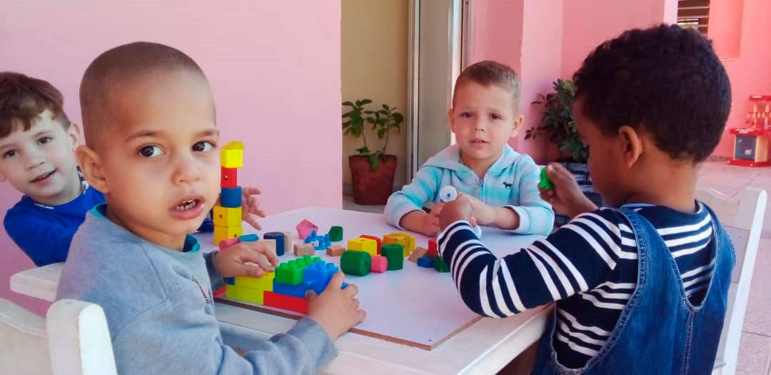 Niños con juegos de mesa en círculo infantil.