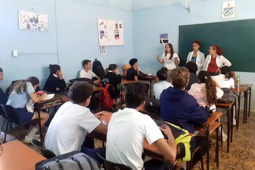 Estudiantes en un aula que reciben conocimientos contra las drogas