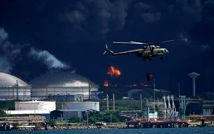 Helicóptero de las FAR en el vertimiento de agua de la bahí­a de Matanzas para controlar el fuego.