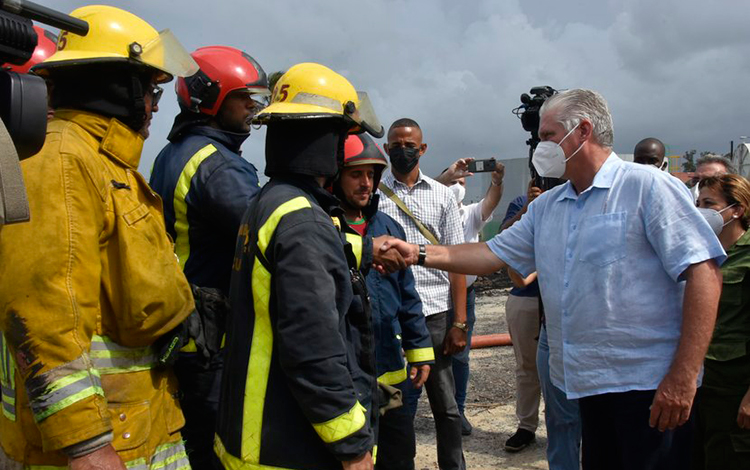 MIguel Díaz-Canel junto a bomberos en el sitio del incendio en la base de supertanqueros de Matanzas.