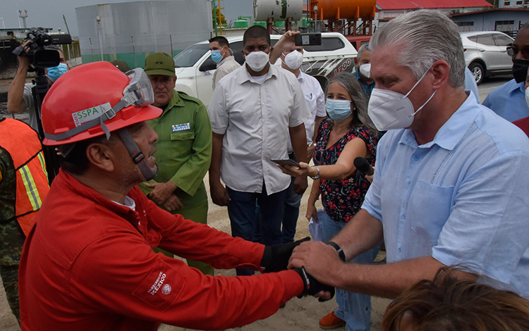 Presidente cubano, Miguel Dí­az-Canel Bermúdez, dialoga con mexicano que participa en la extinción del incendio en la base de supertanqueros de Matanzas.