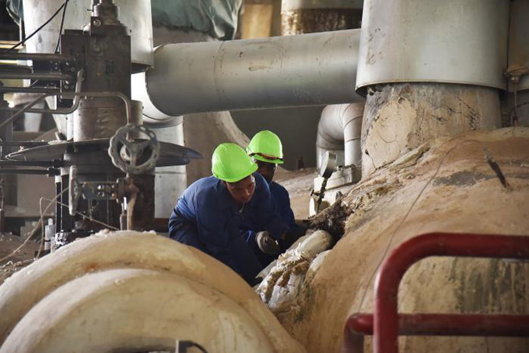 Hombres trabajando en caldera de generación eléctrica