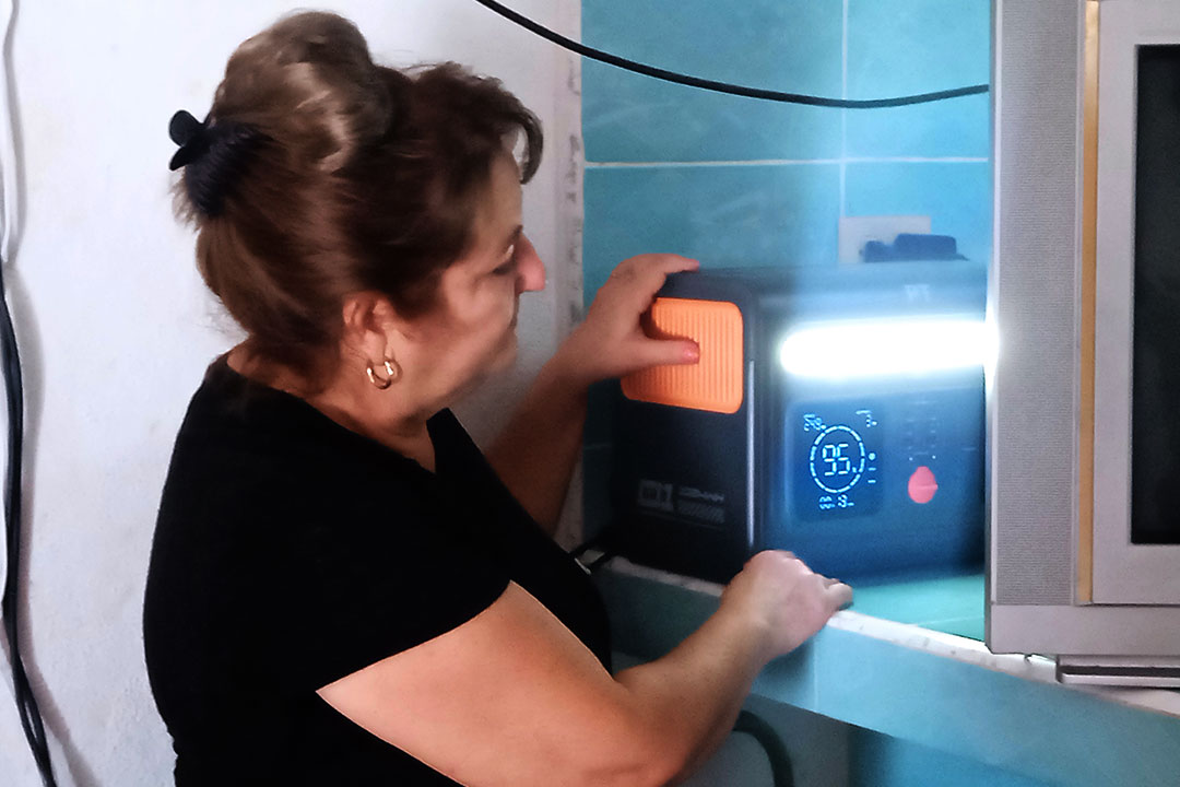 Mujer operando el equipo del sistema fotovoltaico.
