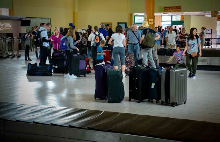 Viajeros con equipajes en aeropuerto.