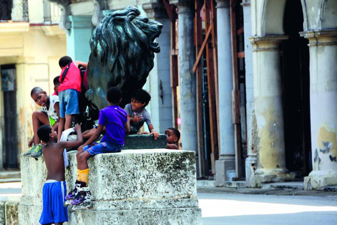 Niños sobre escultura de león