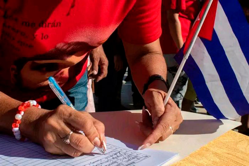 Mujer cubana firma respaldo a la Patria.