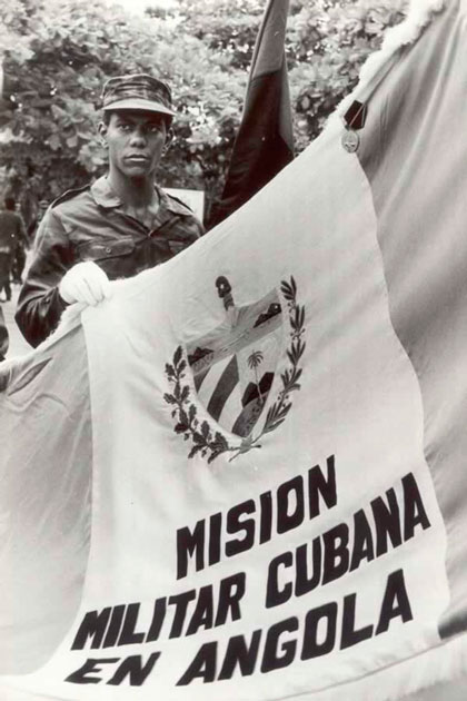 Combatiente con la bandera de la misión militar cubana en Angola.