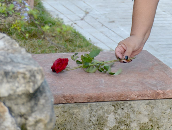 Familiar deposita un flor sobre el nicho que guarda los restos de un combatiente del Frente Las Villas.