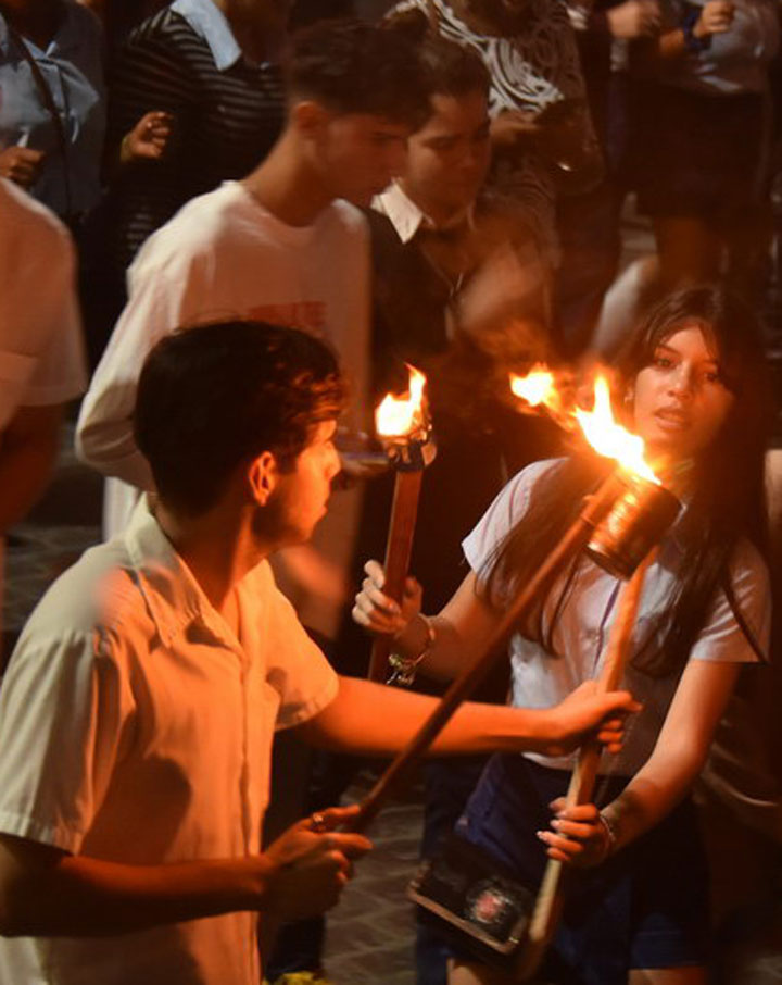 Estudiantes enciende antorchas para honrar a José Martí.