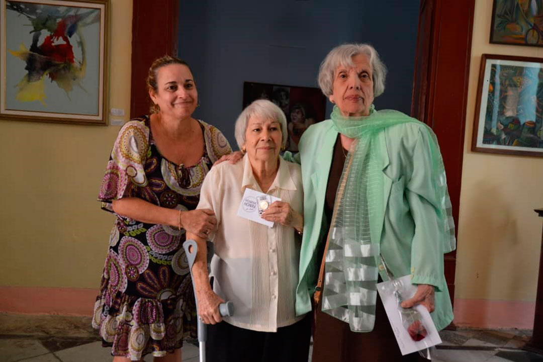 Clara Niebla (al centro) recibe la medalla por el aniversario 25 de a Oficinal del Programa Martiano.