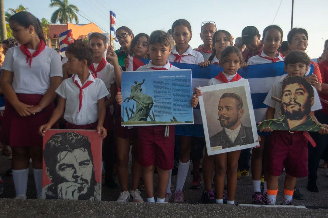 Pioneros con fotos del Che y Maceo.