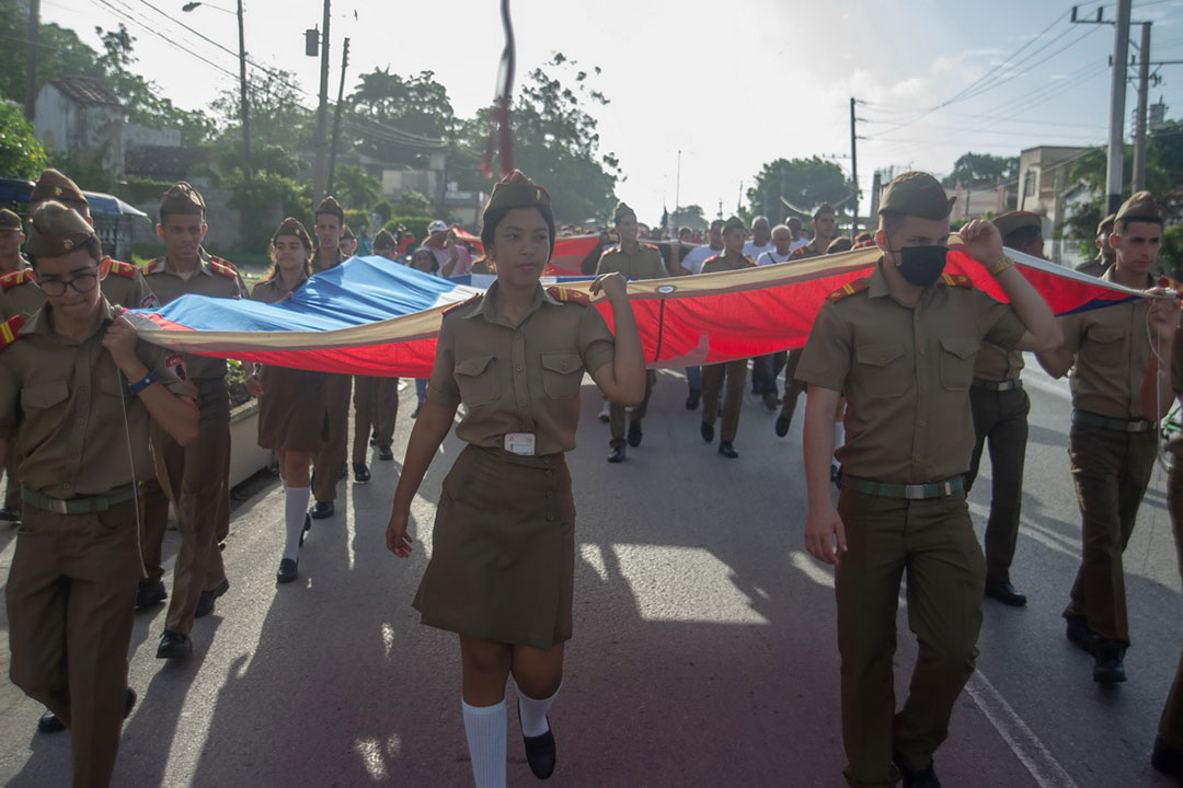 Jóvenes Camilitos encabezan la marcha con la bandera cubana.