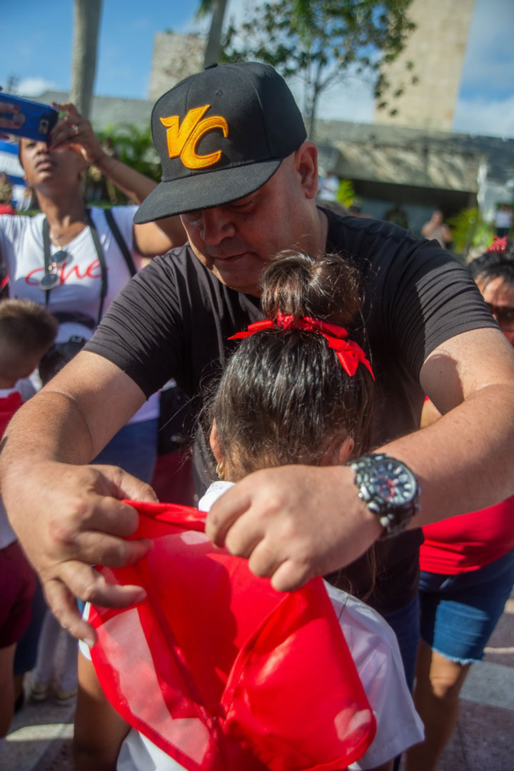 Osnay Miguel Colina coloca la pañoleta roja a pionera santaclareña.