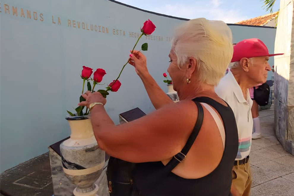 Mujer coloca flores en honor a los mártires.