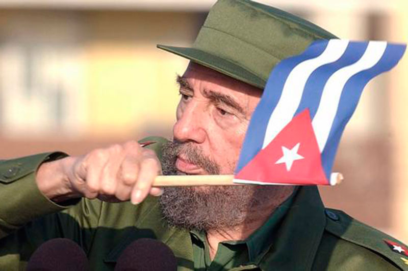 Foto de Fidel Castro Ruz marchando con una bandera cubana en la mano.