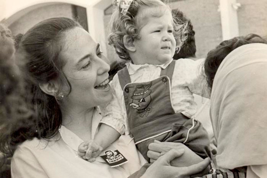 Vilma Espín Guillois con una niña cargada.