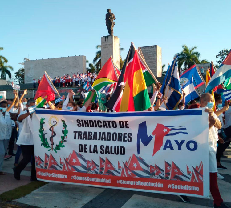 Trabajadores de la Salud desfilan con banderas en la Plaza Ernesto Che Guevara.