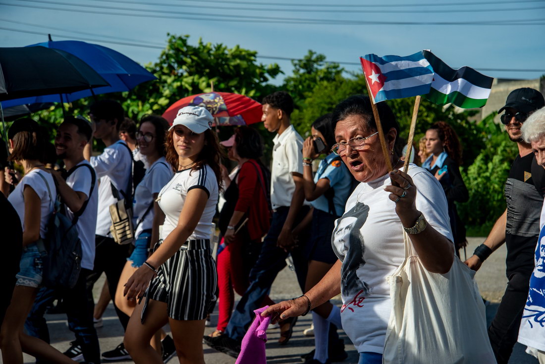 Señora con banderitas de Cuba y de Palestina.