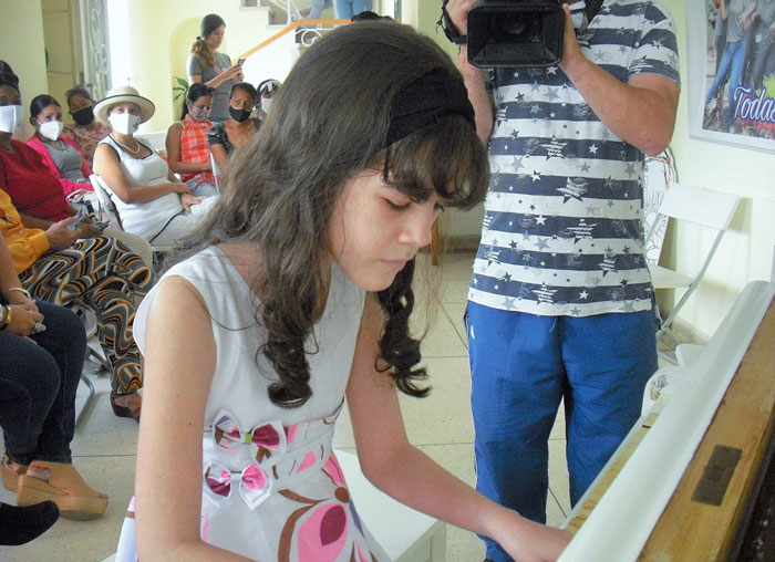 La niña Lena interpreta una obra al piano.