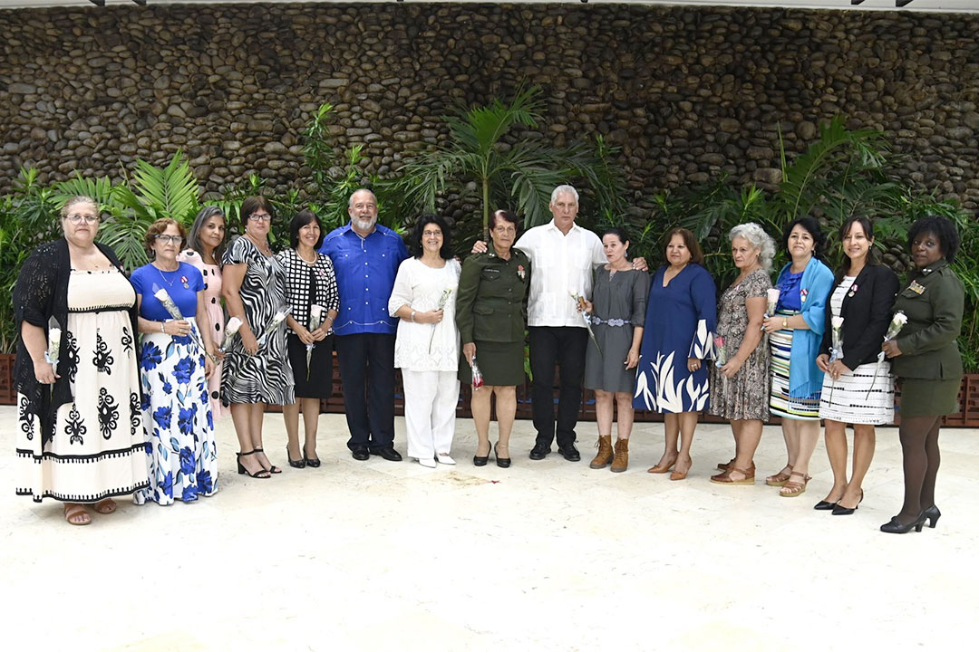 Presidente y primer ministro junto a un grupo de mujeres condecoradas.