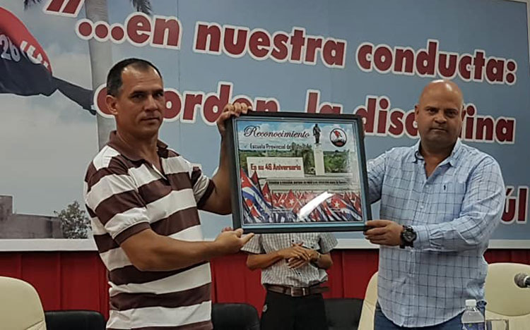  El miembro del Comité Central y primer secretario del partido en Villa Clara,  Osnay Miguel Colina Rodríguez, entregó diploma de reconocimiento a la «Carlos Baliño», recibido por su director, Rafael Benacho García. (Tomada del perfil de Facebook de Dalia Reyes Perera, CMHW)