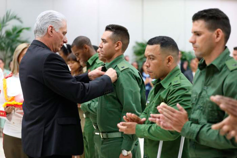 Presidente cubano, Miguel Díaz-Canel, condecora a jóven destacado en la defensa.