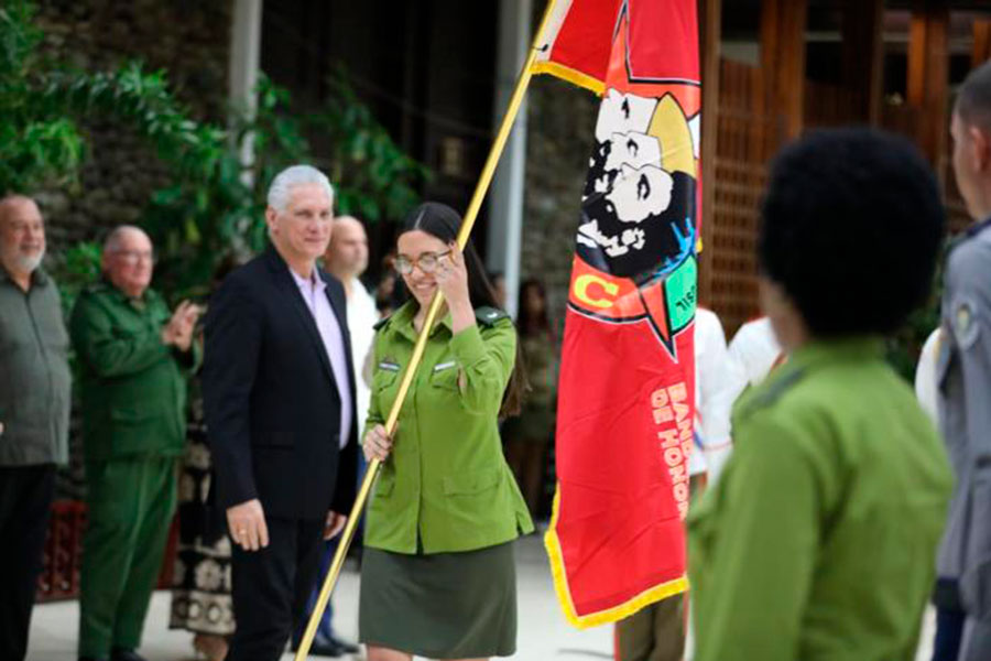 Joven combatiente del Minint porta la Bandera de Honor de la UJC de su colectivo.