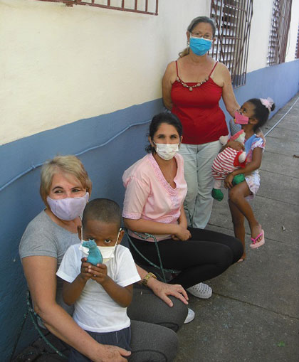 Hermanitos con trabajadoras del hogar de niños sin amparo filial que los acoge en Santa Clara.