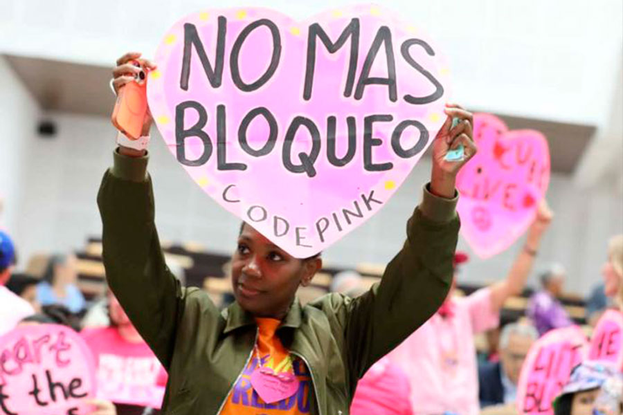 Integrante del Convoy Nuestra América, con cartel contra el bloqueo de EE. UU. contra Cuba.